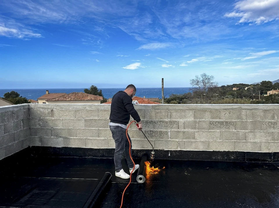 Deux ouvriers en vêtements haute visibilité installent des panneaux d'isolation thermique extérieure sur façade de maison individuelle